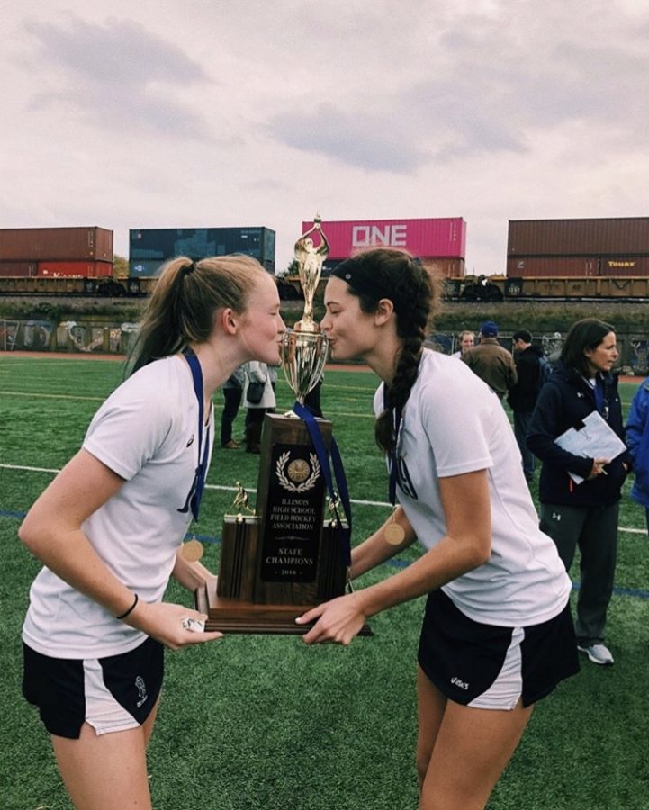 Senior Lucy Murray and Junior Amy Griffin kiss the state trophy