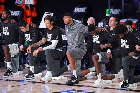 Milwaukee Bucks Giannis Antetokounmpo kneels with teammates during the national anthem 