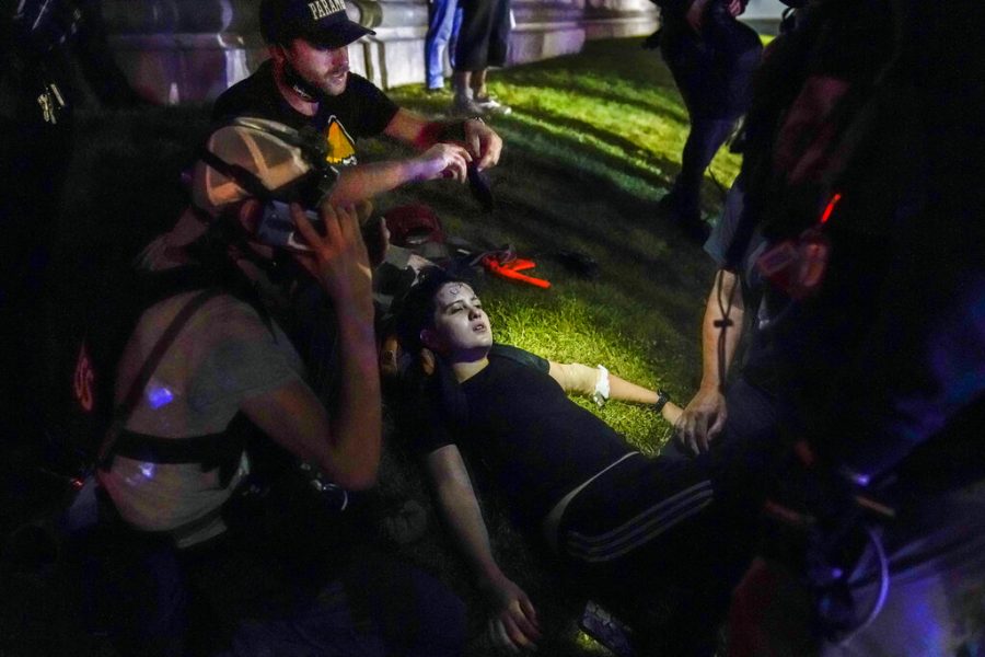Gaige Grosskreutz, top, tends to an injured protester during clashes with police outside the Kenosha County Courthouse in Kenosha, Wis. on Aug. 25. Within minutes, Grosskreutz was shot, Prosecutors say, by 17-year-old Kyle Rittenhouse