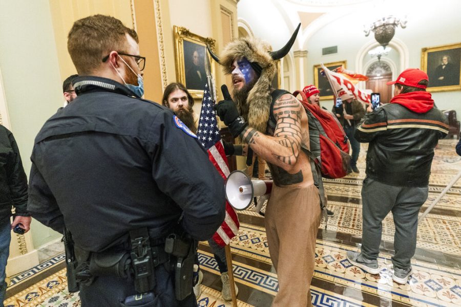 FILE - In this Jan. 6, 2021, file photo supporters of President Donald Trump are confronted by U.S. Capitol Police officers outside the Senate Chamber inside the Capitol in Washington. An Arizona man seen in photos and video of the mob wearing a fur hat with horns was also charged Saturday in Wednesdays chaos. Jacob Anthony Chansley, who also goes by the name Jake Angeli, was taken into custody Saturday, Jan. 9. (AP Photo/Manuel Balce Ceneta, File)