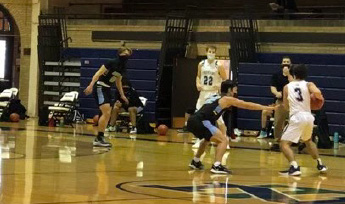 Peter Kanellos dribbles up court in the teams first game, and win, of the season against Maine West on Feb. 6 in Gates Gym