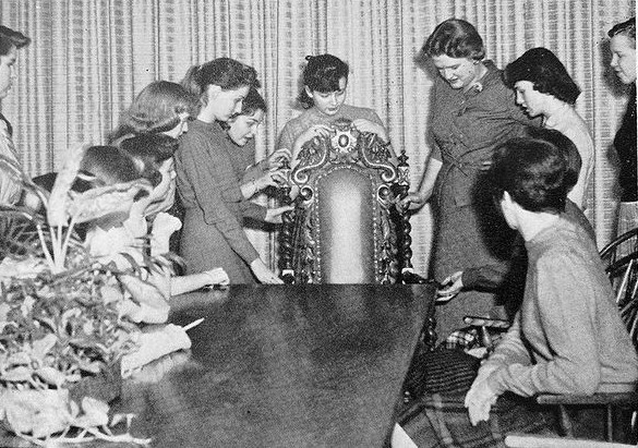  An interior design elective class meets in 1958. Seemingly all-female, the class examines furniture in the photo shown above.