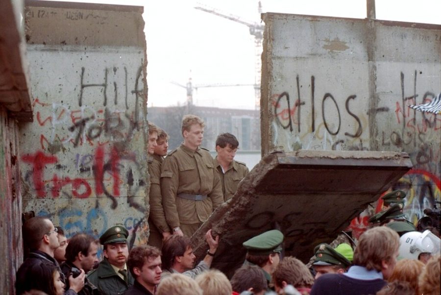 This Nov. 11, 1989 file photo shows East German border guards looking through a hole in the Berlin wall after demonstrators pulled down one segment of the wall at Brandenburg gate. Monday, Nov. 9, 2009 marks the 20th anniversary of the fall of the Berlin Wall. 