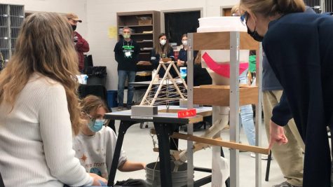Seniors Mia Moline [on the floor] and Elizabeth Feoktistov [right] test their bridge for the build event in Solon, Ohios Invitationals on January 15