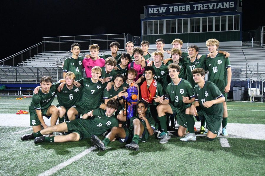 The varsity New Trier Boys Soccer team poses for a team photo after defeating Evanston 2-0 on Sept. 20 to win back the fire hydrant they lost in 2020. 