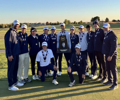 The boys golf team poses with their trophy after their state championship win on Oct. 8