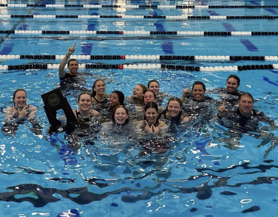 Swimmers+and+coaches+keep+tradition+by+jumping+into+pool+with+state+trophy+following+victory