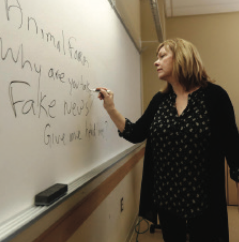 A journalism professor leads a class discussion on fake news