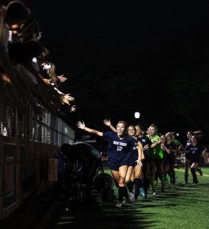 The girls soccer team hi-fives after a 1-0 win against Loyola Academy on May 23, where they advanced to the sectional final