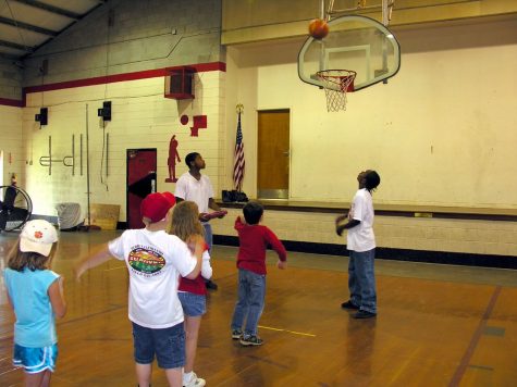Third grade students play basketball in their gym class