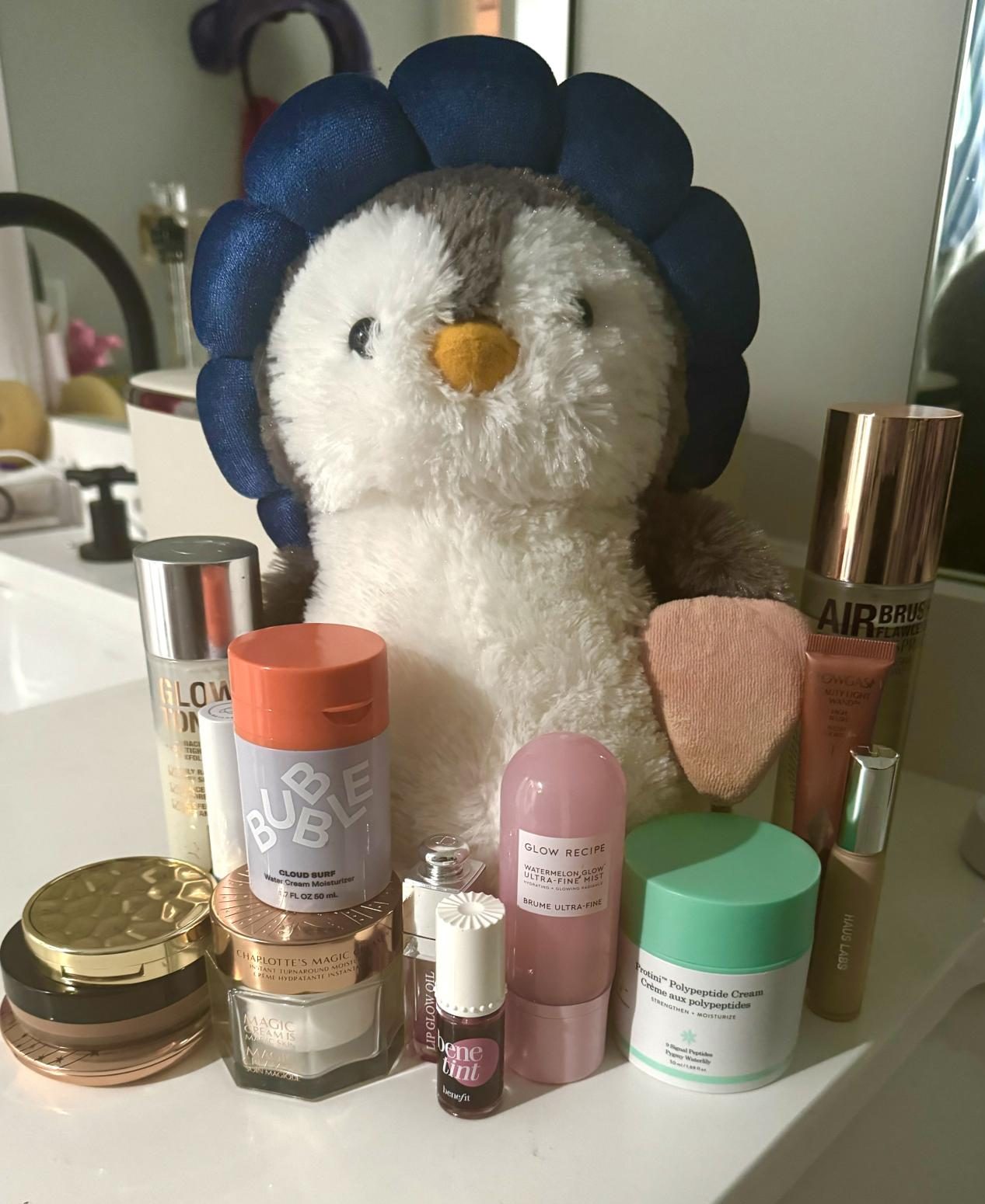 A stuffed animal surrounded by overpriced beauty products commonly owned by pre-teens
