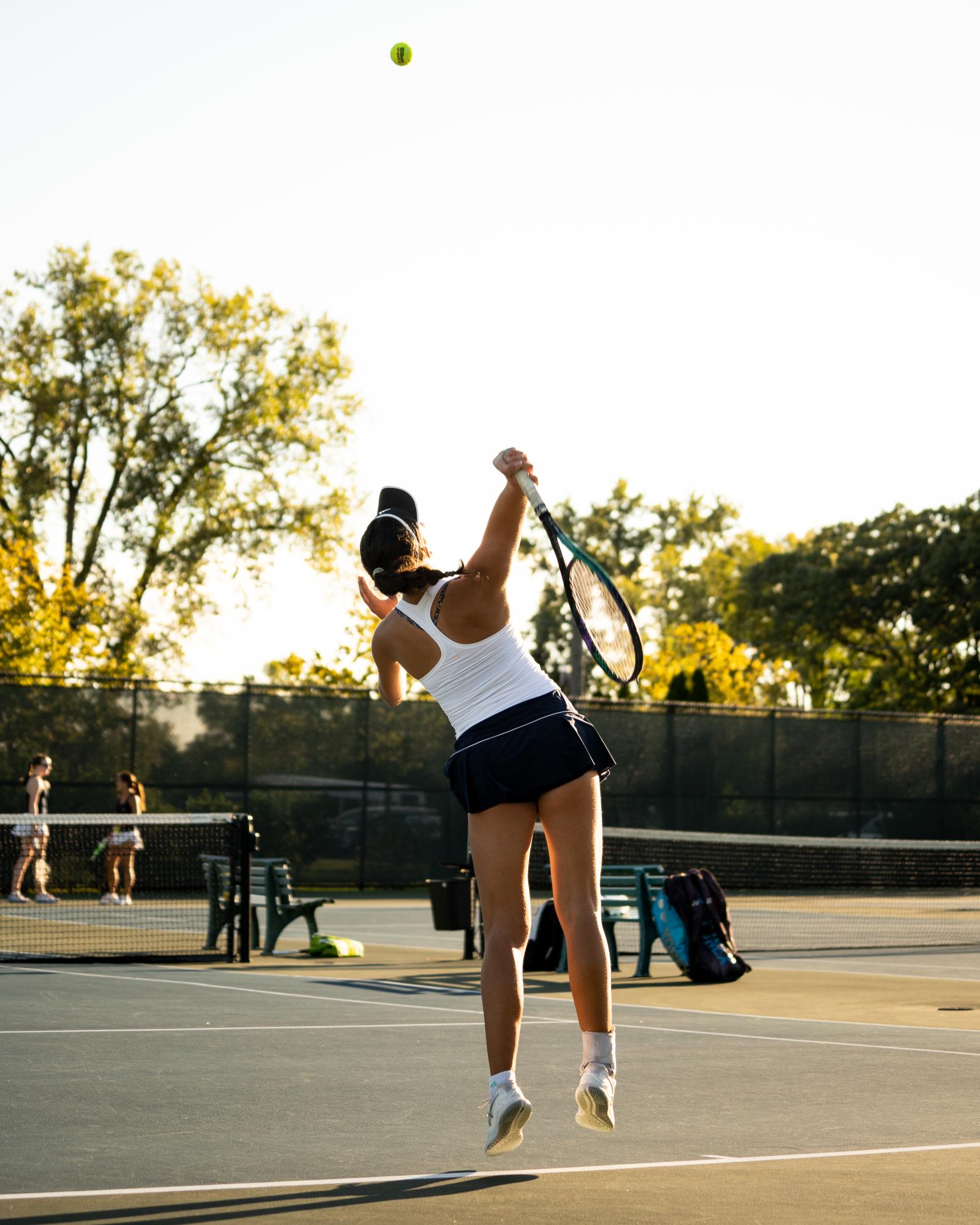 Senior Simran Biggs on the court preparing to hit the ball at conference