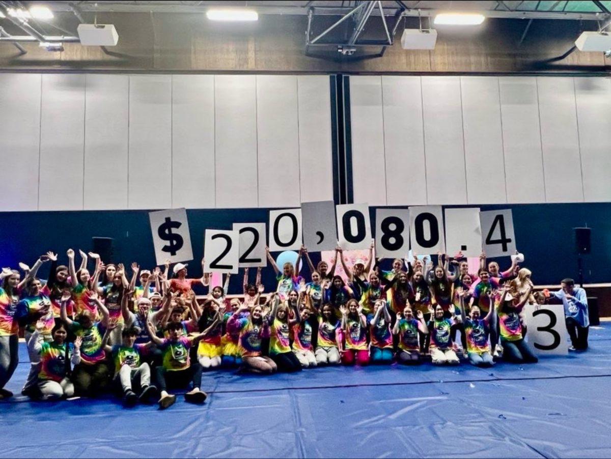 Participants of Bridges Dance Marathon hold up final amount of money raised