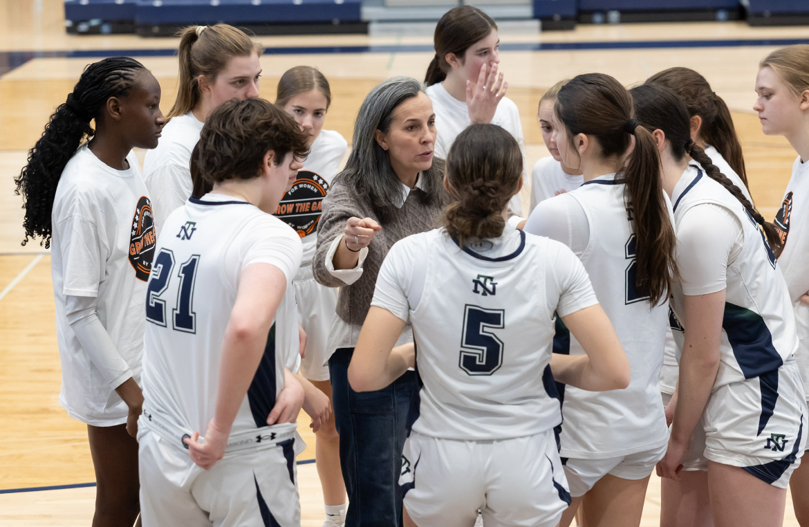 Coach Teri Rodgers leading a pregame meeting to strategize during the Grow the Game tournament
