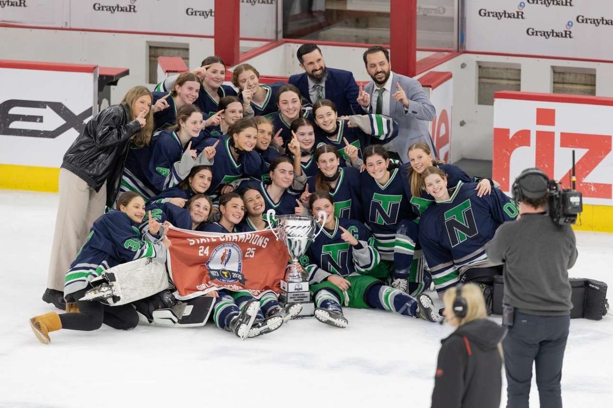 Girls hockey proudly presents their state championship cup and banner after winning 5-4 in a sudden death overtime against Barrington