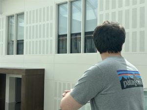 Editor-in-Chief William Karr looks out into the distance on the fourth floor of New Trier High School's Winnetka Campus