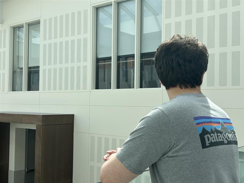 Editor-in-Chief William Karr looks out into the distance on the fourth floor of New Trier High School's Winnetka Campus