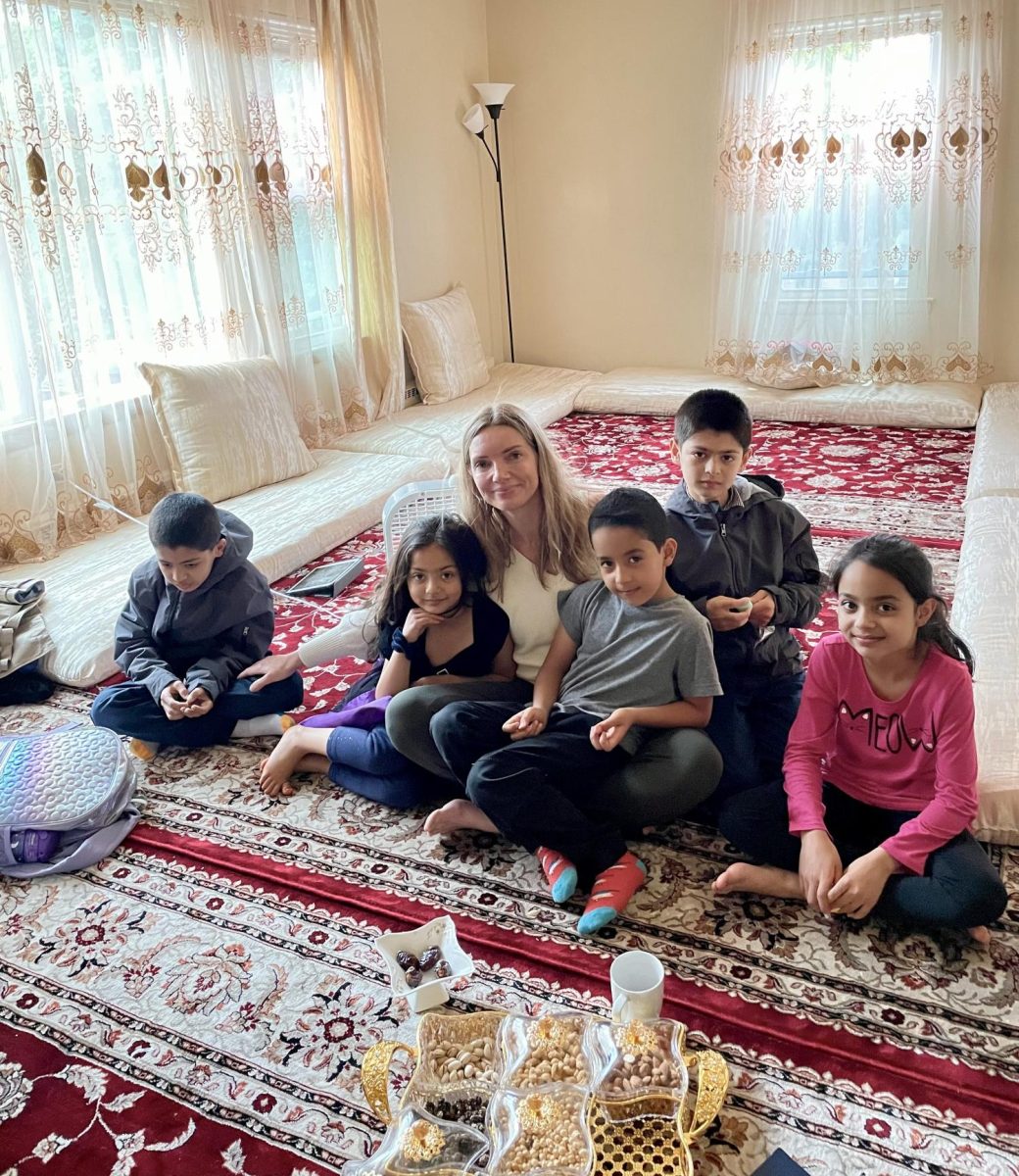 Dita De Leeuw sits with Afghan refugee Roya and her siblings, whom the new nonprofit is named after