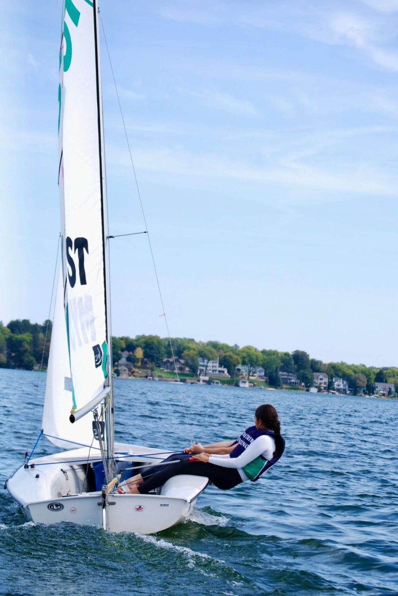 New Trier sailer navigates the boat while out on the water