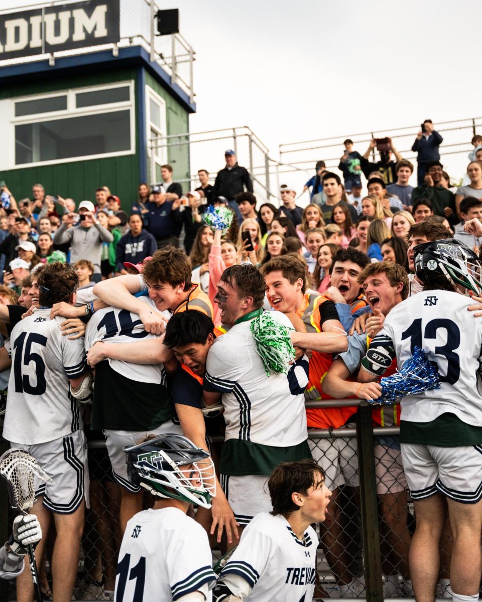 The team celebrates with the student section after their 6-5 sectional victory against Loyola Academy