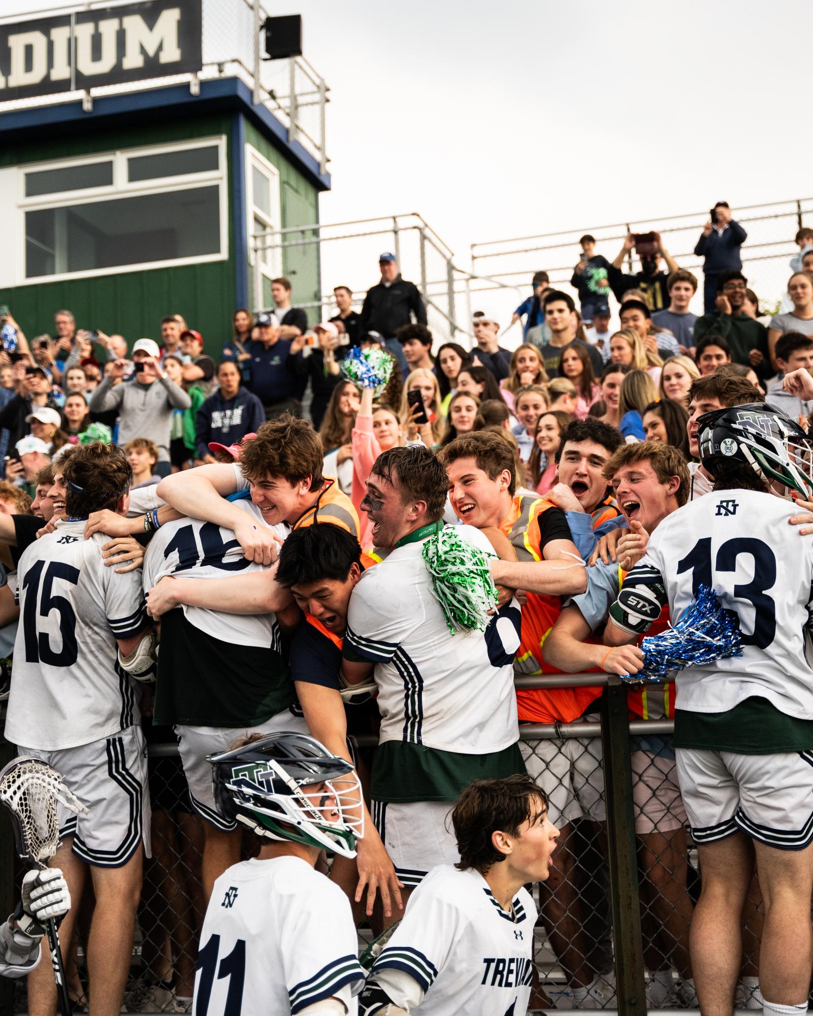 The team celebrates with the student section after their 6-5 sectional victory against Loyola Academy