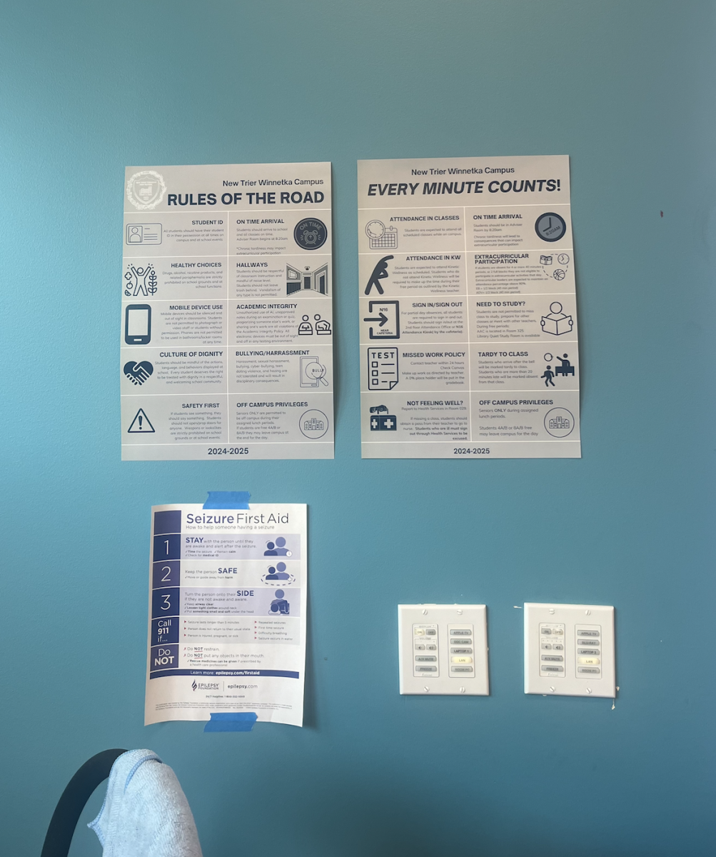 Seizure first aid signage hangs in a classroom, alongside other safety protocol posters