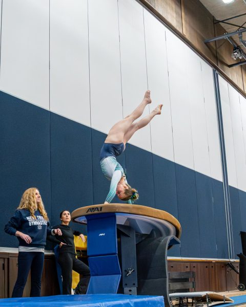Junior Zoey Junker does her vault routine in the team's home opener against Maine East on Dec. 4