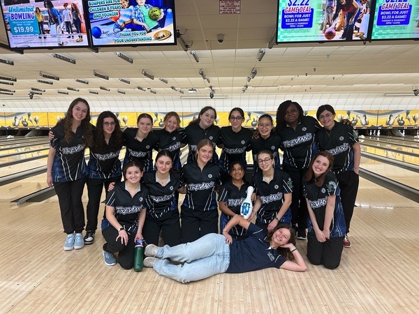 The New Trier girls bowling team poses after defeating Evanston
