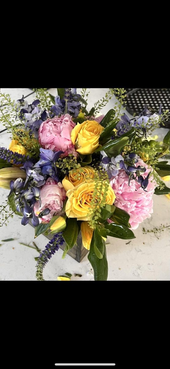 A Petals and Gardens seasonal bouquet composed of roses, greenery, and various filler pieces