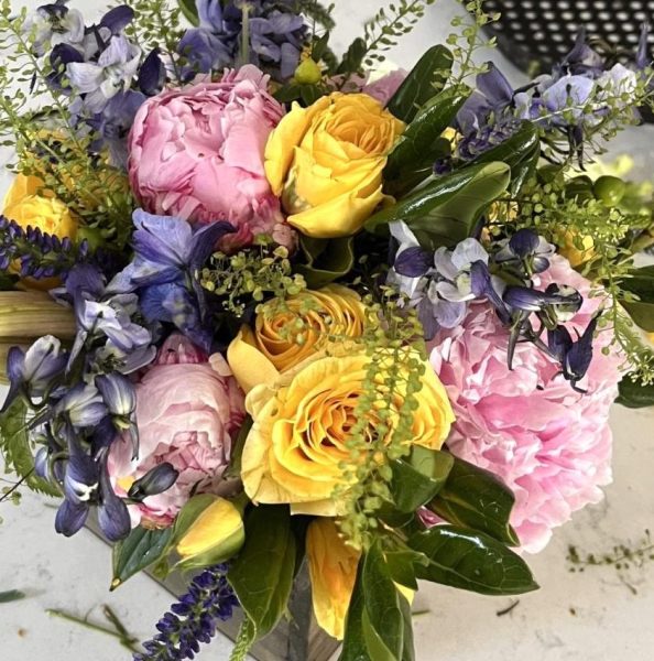 A Petals and Gardens seasonal bouquet composed of roses, greenery, and various filler pieces